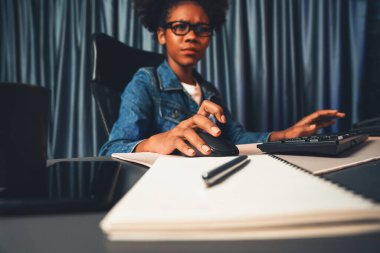 Bilgisayarı veya bilgisayar ekranını yoğunlaştıran, pazarlama veri analizi için fare ve klavye kullanan çalışan Afrikalı kadın blogcu, raporla buluşmak için veritabanında genel bir belge oluşturdu. Tatlandırıcı.