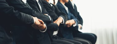 Panoramik afiş ekibi sırada oturup el ele vererek başarılı iş ortaklığını ve iş bulma için profesyonel sinerjiyi, İK işe alım konseptini sembolize ediyor. Kurnaz.