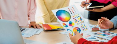 Profesyonel iç mimarın kırpılmış bir görüntüsü, renk örnekleri ve renk paleti belgeleriyle karşılaştırarak iş arkadaşlarıyla renk materyalini tartışıyor. Yaratıcı tasarım konsepti. Değiştirilmiş.