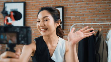 Kadın nüfuzlu kişi video görüntülerini canlı yayınlıyor. Sosyal medya ya da blog. Stüdyo ışıklandırması olan mutlu genç bir kız pazarlama için internet üzerinden yayın yapıyor..