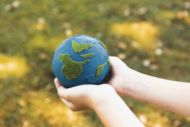 Dünya gezegenini ESG ilkesi ve çevre dostu enerjisiyle daha parlak bir gelecek için Dünya günü olarak el ele tutuşan genç çocuklar. Döngü