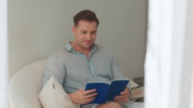 Kanepede oturan orta yaşlı bir adam, sosyal ve teknolojik mesleki gelişmeler hakkında ders kitabı okur ya da çocukları iyi bir yetişkin baba olmak için yetiştirir. Hayat boyu öğrenme konsepti. Uyumsuzluk.