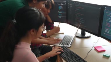 Yavaş çekim arkası yazılım geliştirici mühendisi bilgisayar programlama için birlikte çalışarak hata ayıklama kodunu çözüyor, ofiste monitörde karmaşık algoritmaları çözüyor. Filizlenen