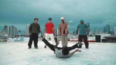 İspanyol hipster dansları şehrin mavi gökyüzü manzaralı çok kültürlü arkadaşlarıyla çevrili. Çatıda bir grup sokak dansçısı sahne alıyor. Aktif, eğlenceli, mutlu atmosfer. Açık hava sporu 2024 hiphop..