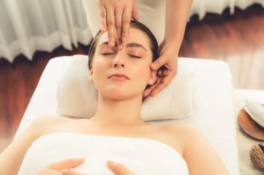 Kafkasyalı kadın stres önleyici kafa masajından ve lüks tatil beldesi ya da otel spa salonundaki modern ışık ortamında yüz güzelliği eğlencelerini şımartmaktan hoşlanıyor. Sessiz.