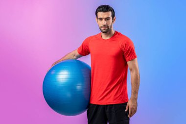 Vücut uzunluğunun tamamı atletik ve sportif genç bir adam tarafından izole edilmiş arka planda topu ayakta tutarken çekildi. Sağlıklı aktif ve vücut bakımı yaşam tarzı.
