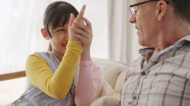 Büyükbaba ve torun birlikte TV 'de eğlence medyası hakkında konuşuyorlar. Eski usul konuşmalar, genç nesillerle iletişim kurarak aile bağlarını güçlendirir. Uyumsuzluk.