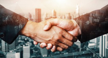 İş adamlarının arka plandaki belediye binasında el sıkışması ortaklık anlaşmasının başarısını gösteriyor. Kurumsal takım çalışması, güven ortağı ve iş anlaşması kavramı. uds