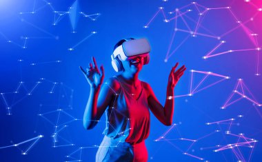 Beyaz VR kulaklık takan ve metaevreni birleştiren kolsuz tişört giyen, gelecekteki siber uzay topluluğu teknolojisi olan bir kadın siber punk neon ışığı altında el ve vücut hareketleriyle dans etmekten zevk alıyor. Halüsinasyon.