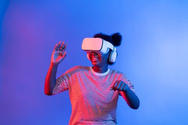 VR kullanan genç Afrikalı oyuncular, metaevrene dönüyor. Motosiklet yarışmacısı, meta şehirde neon ışık bağlantılı fütüristik teknoloji sanal gerçekliğini izole ediyor. Entrika.