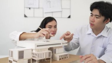 Profesyonel akıllı iş birliği mühendisi mühendis ekibi modern ofisteki ev yapısını planla kontrol ederken genç ve güzel proje yöneticisi not alıyor. Yaratıcı tasarım konsepti. Tertemiz...