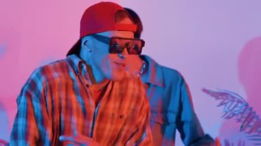 Break dansçı takımının modern stüdyoda pembe ışıkla dans etmesini kapatın. Çok kültürlü insanlar moda kıyafetleri giyerek hip hop müziğine geçiyorlar. Çılgın, komik bir ruh hali. Mutluluk.