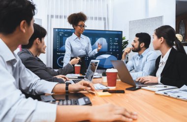 Genç Afrikalı iş kadını modern toplantıda TV ekranında veri analizi paneli sunuyor. Bir grup iş adamıyla konferans odasında iş sunumu. Uyum