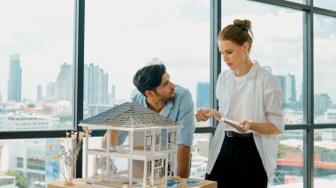 Yetenekli mimar mühendis takımı ev modeli inşaatı hakkında konuşuyor. Akıllı iç mimar paylaşımı, güzel bir iş arkadaşı not alırken bina tasarımından bahsetmek. Tasarım. İzleme