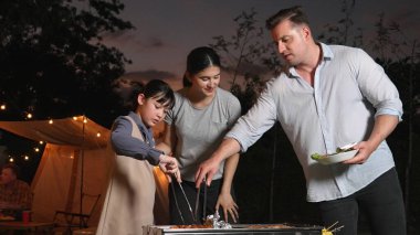Family celebrate holiday in garden. Father, mother and child grill food for member. Outdoor camping activity to relax with meal and spend time with young generation cross generation gap. Divergence. clipart