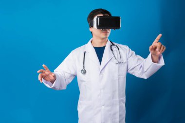 VR kulaklık takan zeki bir doktor metaevren seçerek tıbbın detaylarına yakınlaştırıyor mavi arka plan fütüristik teknoloji hologramı sanal gerçeklik zeki meta dünya. Entrika.
