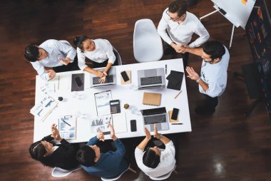 Üst düzey ofis çalışanları stratejik iş pazarlama toplantısı üzerine anlaşma yaptıktan sonra el sıkışıyor. Takım çalışması ve olumlu tutum verimli ve destekleyici bir iş yeri yaratır. Tedbirli