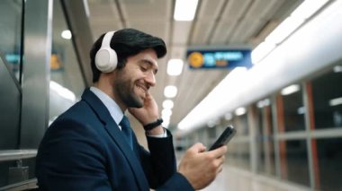 Tren istasyonunda geçmişi bulanık bir şekilde beklerken kulaklıkla müzik dinleyen zeki bir iş adamı. Yetenekli proje yöneticisi cep telefonu tutarken dinlenme sesi dinlemeyi sever. Sevinçli..