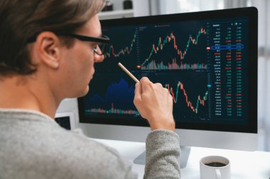 Akıllı yatırımcılar bilgisayar ekranlı ilginç borsa takasını işaret ediyorlar. Finansal teknoloji dinamik yatırım planı modern işyerindeki veri grafiğine odaklanıyor. Bireysel.