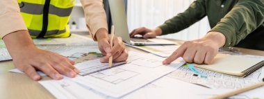 Modern ofiste mimari ekipman ve planlarla toplantı masasında ev tasarımı üzerine profesyonel mühendis ekibi tartışması. Eline odaklan. - Yakın çekim. Tanımlama.