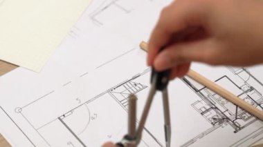 Bölücü araç ve el yazısı kullanan akıllı mimar ya da güvenlik mühendisinin videosu mimari ofisteki inşaat doğruluğu planının ayrıntılarını içeriyor. Eline odaklan. - Yakın çekim. Tanımlama.
