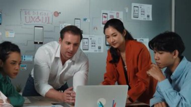 Profesyonel başarılı iş ekibi dizüstü bilgisayar kullanarak birlikte çalışıyor. Bir grup iş adamı projeyi tartışırken Asyalı genç iş kadını dizüstü bilgisayar getiriyor. Yönlendirici.