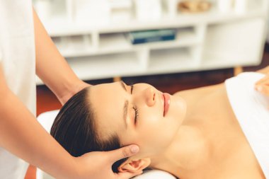 Kafkasyalı kadın stres önleyici kafa masajından ve lüks tatil beldesi ya da otel spa salonundaki modern ışık ortamında yüz güzelliği eğlencelerini şımartmaktan hoşlanıyor. Sessiz.