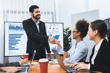 Çeşitli iş arkadaşları bunu şirket işyerinde el sıkışma ve takım çalışmasıyla kutluyor. Başarılı bir toplantıdan sonra el sıkışmayla ya da veri analizi üzerine iş sunumuyla birleşen mutlu iş adamları. Uyum