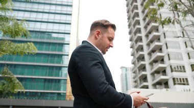 Düşük açılı kamera görüntüsü iş adamının telefonuna bakarken pazarlama ekibini arayıp Green City 'deki finansal plan hakkında fikir alışverişinde bulunması. Yönetici, iş arkadaşıyla telefonla konuşuyor. Urbane.