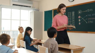 Zeki öğretmen sınıfta fikri açıklarken sevimli öğrenci ödevlerini kontrol ediyor. Not defterine bakıp matematik teorisinden çocuğa bahsederken sınıfta dolaşan çekici bir eğitmen. Pedagoji.