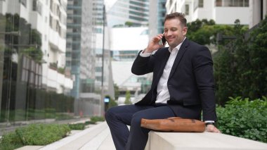 Kafkasyalı işadamı, müdürle telefonda plan stratejisi hakkında konuşurken bankta oturuyor. Profesyonel yönetici pazarlama ekibini arıyor ve şehirde yaratıcı fikirleri paylaşıyor. Urbane.
