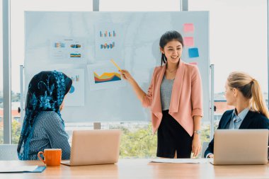 Çok kültürlü çalışma grubu. Farklı etnik kökenden iş kadınları, Kafkasyalı, Asyalı ve Araplardan oluşan bir ekip ofiste dizüstü bilgisayarla birlikte çalışıyor. Çok ırklı takım çalışması konsepti. uds