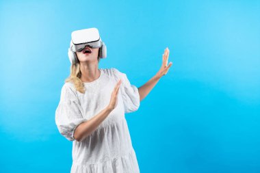 Arka planda sanal gerçeklik gözlüğü kullanarak metaevrenden etkilenen pijamalı yetenekli bir kız. Beyaz kadın, görsel gerçeklik gözlüklerine bakarak etrafına bakınırken şaşırdı. Kısıtlanma.