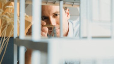 Kafkasyalı mimar mühendisin ev inşaatını teftiş ederken ve bina malzemelerini incelerken yakın çekim görüntüsü. Proje yöneticisi modele dikkatlice bakarken kalemi işaret ediyor. Yönlendirici.