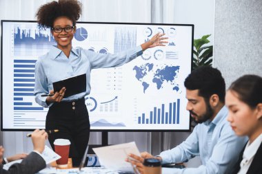 Genç Afrikalı iş kadını modern toplantıda TV ekranında veri analizi paneli sunuyor. Bir grup iş adamıyla konferans odasında iş sunumu. Uyum