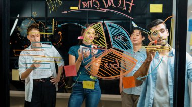 Yetenekli erkek lider, istatistik grafiğini uzman yatırımcılara açıklıyor. Akıllı iş adamı sunar, finans planlarını gece ofisindeki cam duvardaki yatırımcılara gösterir. İş konsepti. İzleme