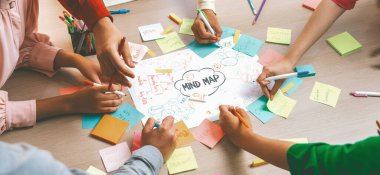 Yaratıcı bir girişim grubu beyin fırtınası fikri. Genç ve güzel iş adamları birlikte çalışıyor ve renkli yapışkan notlarla fikirleri paylaşıyorlar. Eline odaklan. Üst Manzara. Değiştirilmiş.