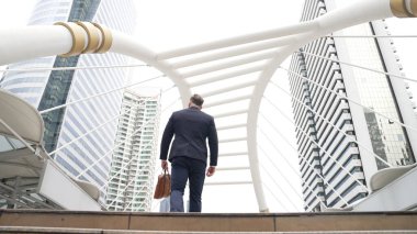 Kafkasyalı zeki işadamı şehir manzarası ile çevrili merdivenleri çıkıyor. Hırslı proje yöneticisinin modern inşaatta zorlu bir iş ya da yatırım fırsatı bulması. Urbane.