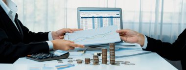 Kurumsal muhasebeci, vergi iadelerini hesaplamak ve maksimuma çıkarmak için dizüstü bilgisayar üzerinde muhasebe yazılımı kullanır ve Panorama 'daki iş yatırım yığını madeni para konseptiyle finansal performansı artırır. Kurnaz.