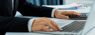 Şirket muhasebecisi, mali veri raporuna dayanarak vergi iadelerini hesaplamak ve en yüksek seviyeye çıkarmak ve finansal performansı artırmak için hesap makinesi kullanır. Panorama 'daki modern muhasebe. Kurnaz.