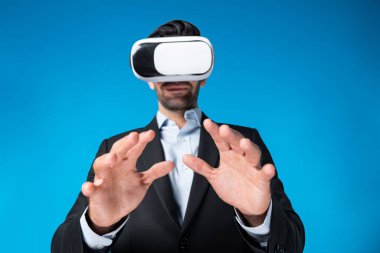 Takım elbiseli zeki bir iş adamı metaevreni bağlamak için sanal gerçeklik gözlüğü takıyor. Profesyonel proje yöneticisi görsel gerçeklik kulaklığı kullanarak holograma bakıyor. Teknoloji yeniliği. Sapma.