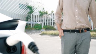 Yavaş çekim adamı, EV şarj aletini şehrin alışveriş merkezinin otoparkındaki şarj istasyonundan şarj etmek için kullandı. Sürdürülebilir şehirde EV aracı tarafından şarj edilebilir enerji olarak kullanıldı.