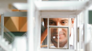 Kafkasyalı mimar mühendisin ev inşaatını teftiş ederken ve bina malzemelerini incelerken yakın çekim görüntüsü. Proje yöneticisi modele dikkatlice bakarken kalemi işaret ediyor. Yönlendirici.