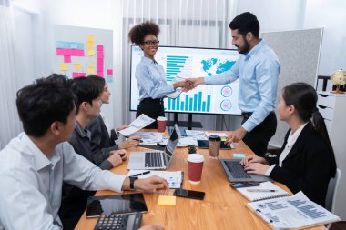 Çeşitli iş arkadaşları bunu şirket işyerinde el sıkışma ve takım çalışmasıyla kutluyor. Başarılı bir toplantıdan sonra el sıkışmayla ya da veri analizi üzerine iş sunumuyla birleşen mutlu iş adamları. Uyum