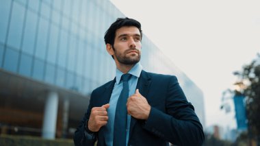 İş adamının portresi yolda yürürken kravatı ayarlar. Yönetici şehre bakarken takım elbise giyiyor. Yatırımcı görüşmeye gitmeden önce kendini kontrol etmiş. Arka plan bulanık. Sevinçli..