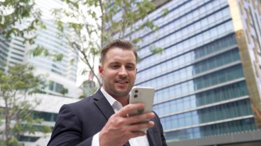 Düşük açılı kamera görüntüsü iş adamının telefonuna bakarken pazarlama ekibini arayıp Green City 'deki finansal plan hakkında fikir alışverişinde bulunması. Yönetici, iş arkadaşıyla telefonla konuşuyor. Urbane.