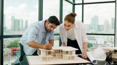 Kooperatif mimar mühendis ekibi kalem kullanarak ev modelini ölçmek için birlikte çalışıyor. Başarılı bir Kafkas iç mimari tasarım ekibi mimari model yapısını inceliyor. Tasarım. İzleme