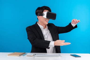 Asyalı işadamı VR 'ı kullanarak veri nesnesini havada tutuyor iş dünyasının fütüristik yenilikçi teknolojisini analiz ediyor izole edilmiş mavi telif uzayındaki sanal gerçekliği inceliyor. Entrika.