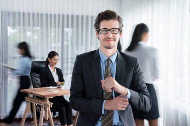 Kameraya bakan mutlu iş adamının portresi iş dünyasındaki hareketlerin hareket bulanık arka planına sahip. Habiliment