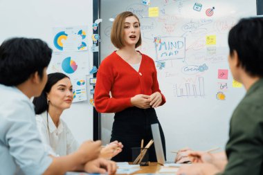Profesyonel çekici kadın lider, modern iş toplantı odasında beyin fırtınası zihin haritalama istatistikleri ve renkli yapışkan notlar kullanarak yaratıcı pazarlama planını sunuyor. Tertemiz..